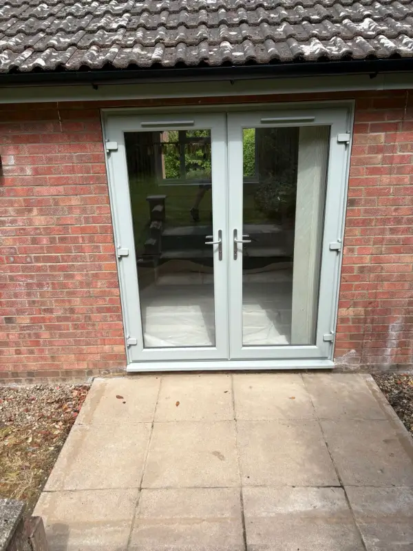 Stone Grey uPVC French doors beneath renewed fascia and black guttering in Ipswich